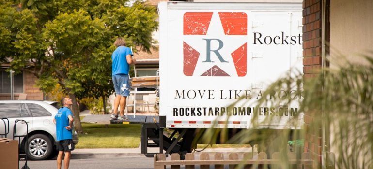 Two movers loading furniture onto Rockstar moving truck 