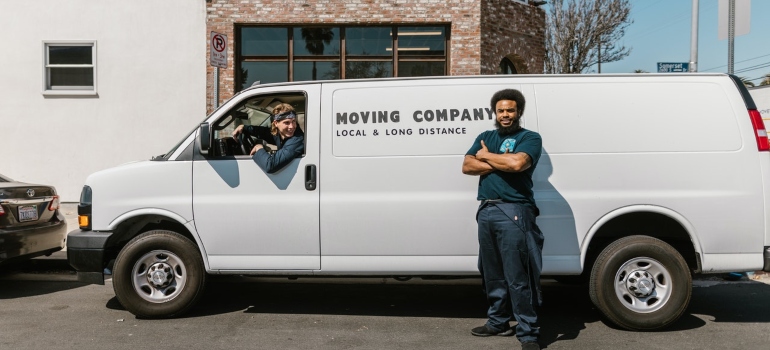 a moving company truck and workers in front of it