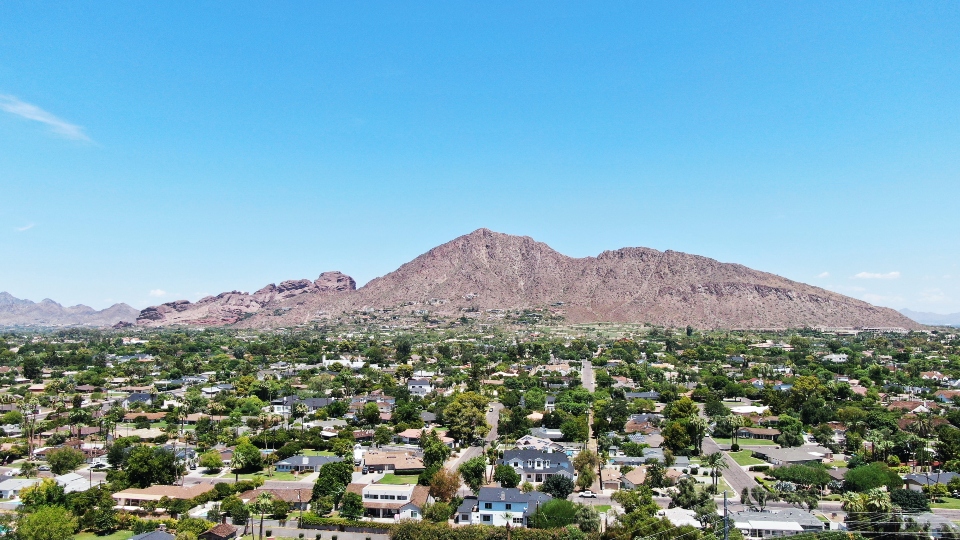 A hill in Phoenix photographed from the distance during a sunny day.