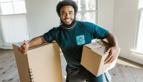 one of the reliable cross country movers standing next to the moving boxes