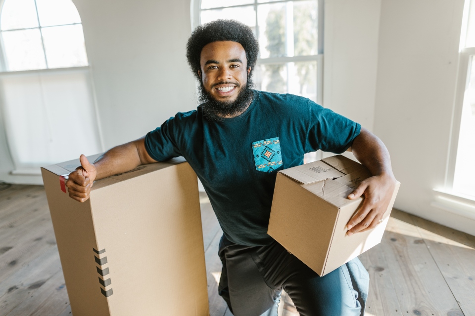 one of the reliable cross country movers standing next to the moving boxes