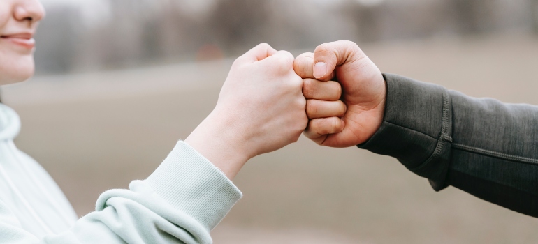 two people giving each other fist bump after successfuly moving from SF long distance on weekends