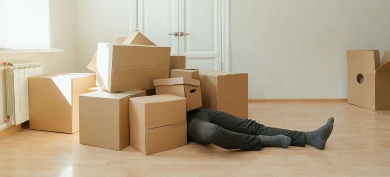 a man under a pile of cardboard boxes