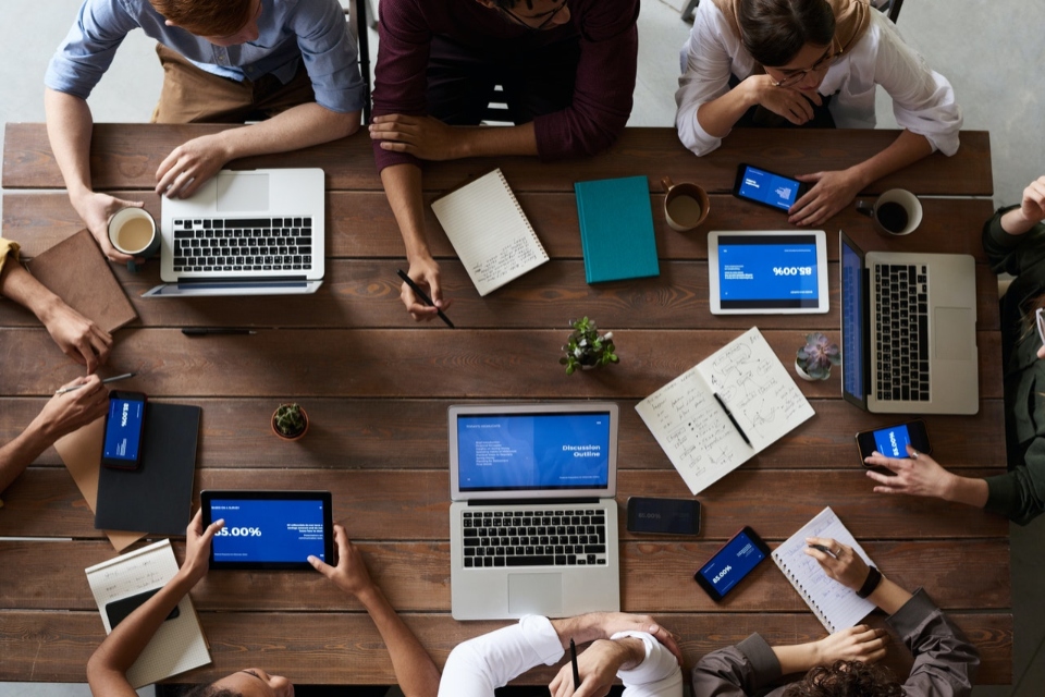 people with laptops sitting at a table