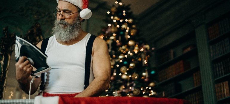 Santa Claus is ironing his suit