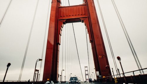 Modern cars driving along suspension bridge