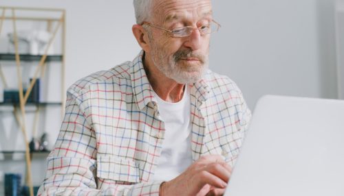 Old man reading guide to stress-free moving for seniors in CA