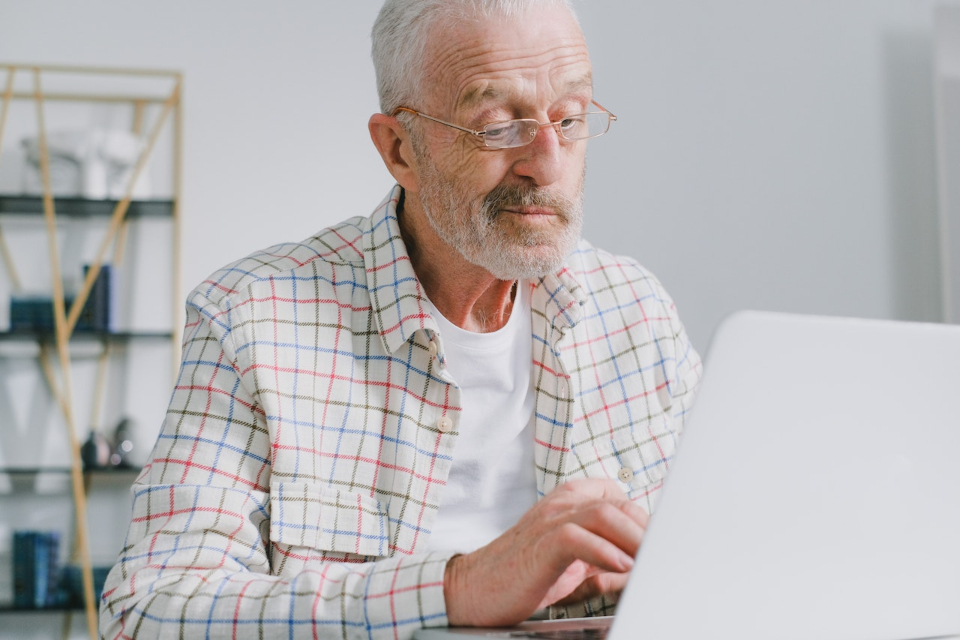 Old man reading guide to stress-free moving for seniors in CA