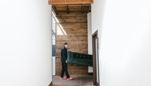 Man carriying a green sofa