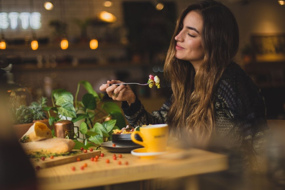 A woman eating in some of the best vegan restaurants in LA