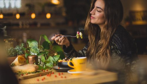 A woman eating in some of the best vegan restaurants in LA