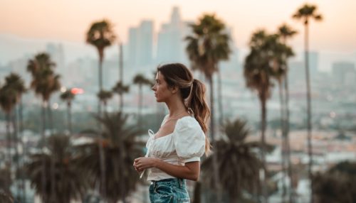 A woman standing in one of the busy streets of California